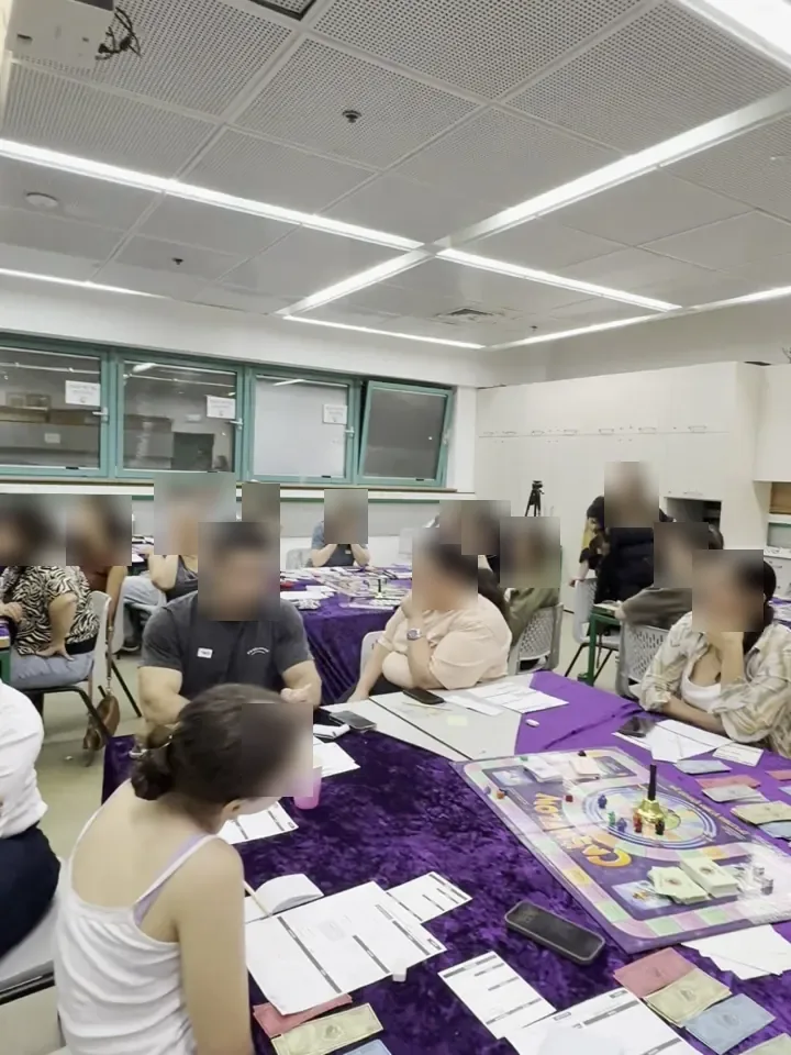 כיתה מלאה במשתתפים סביב שולחנות עם לוחות משחק קאשפלואו בזמן הסדנה